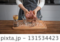 Close-up of female hands mixing fresh meat mince in a clear bowl. Preparing homemade patties. 131534423