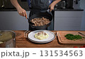 Unrecognizable woman plating Beef Stroganoff with mashed potatoes. Homemade dinner serving. 131534563