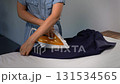 Unrecognizable woman ironing a man's shirt at home. Domestic life chore. 131534565