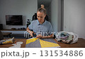 Woman cutting fabric pieces using templates and scissors. Preparing for sewing. 131534886