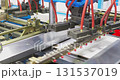 Industrial robotic arm handling metal sheet in factory 131537019