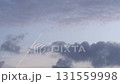 A clear sky with soft clouds and a visible contrail. The scene captures the tranquility of nature and the impact of human activity in the atmosphere. 131559998