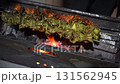 grilling kebab over fiery coal flames 131562945