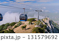 Cable car cabins moving above mountain slopes and clouds - Babadag 131579692