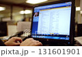 Close up of hands typing on a computer keyboard in a busy office environment 131601901