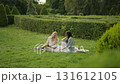 Friends enjoying a picnic in a beautiful garden 131612105