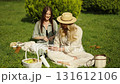 Friends enjoying a picnic in a sunny park 131612106