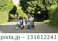 Friends enjoy a sunny afternoon practicing skateboarding skills on a quiet street surrounded by greenery 131612241