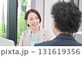 お客様や同僚とデスクに座りパソコンで説明や打ち合わせをする営業女性などの爽やかなイメージ　説明やプレ 131619356