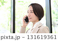 オフィスの電話をかける通話するスーツを着た女性のビジネスシーン　見上げるクローズアップの動画	 131619361