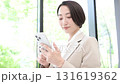 新緑のオフィスの窓際でスーツでタップする女性のビジネスシーン　問い合わせや連絡など動画	 131619362