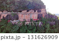 Aerial view of a wooden walkway built along a dramatic cliff face surrounded by lush green forest, showcasing adventure travel, hiking trails, and natural scenic beauty, Phu thok temple, Thailand 131626909