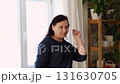 Senior woman dance at home. Elderly lady listening song and moving. Old female brunette feels calmly, relish carefree retired life looks happy. Vitality, wellness. Grandmother dancing alone indoors. 131630705