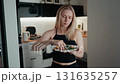 Woman smiling and eating salad, lifestyle atmosphere highlights home dining, lifestyle energy connects food and health, lifestyle moment inspires modern visual storytelling. Female enjoying salad bowl 131635257