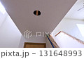 A staircase in a home undergoing renovation, featuring protective coverings and masking tape to safeguard surfaces. The area is prepared for painting or further construction work, highlighting a 131648993