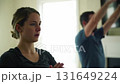 Young woman and man doing yoga exercises at home, focusing on wellness and healthy lifestyle 131649224