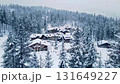 Aerial view of a charming snow covered village nestled among pine trees in a winter mountain landscape 131649227