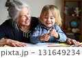 Smiling grandmother and little boy drawing with crayons, enjoying creative activity at home 131649234