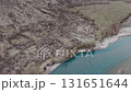 Aerial view of a serene river flowing through a mountainous region in Pakistan, adorned with blooming orchards 131651644