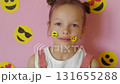 The person puts emoji stickers on their face. The use of emoticons for the convenience of communication and transmission of emotions in social media. World Smile Day 131655288