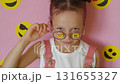 A sly, curious girl with glasses and smiley stickers with various emotions. The use of emojis in communication of the modern generation 131655327
