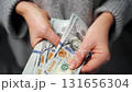 Woman counting US Dollar bills, close-up 131656304