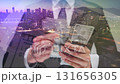 Double exposure of a man counting US Dollar bills against the modern city 131656305