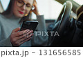 Happy beautiful woman using smartphone while waiting in the car. 131656585