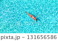 Top down view of a woman in pink swimsuit lying on her back in the pool. 131656586