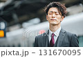 ビジネスマンの休息、駅のホームで目を閉じる男性、電車、リラックス 131670095