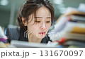 書類に囲まれて悩む女性、仕事、集中、表情に注目 131670097