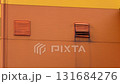 Orange industrial wall with moving ventilation grille creating rhythmic motion and industrial mood 131684276