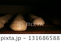 Loaves of raw dough are on the conveyer in an oven 131686588