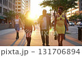 People walk along the street of a big city in the rays of the setting sun. 131706894