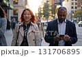People walk along the street of a big city in the rays of the setting sun. 131706895