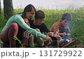 Family roasting marshmallows over campfire 131729922