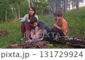 Family camping adventures: roasting food on campfire 131729924
