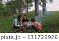 Family camping fun: roasting food on sticks by campfire 131729926