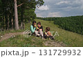 Family enjoying apples on a hillside 131729932