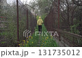 a girl with a beautiful figure in a yellow hoodie and black sweatpants enjoys a walk in the countryside on a cloudy summer day, looking at beautiful views and local old houses 131735012