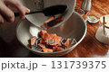 Chef pours diced salmon pieces into a bowl, seasons them with various spices, and mixes thoroughly. 4K close-up of cooking preparation process. 131739375