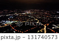 An aerial view of a city reveals its vibrant lights and busy night activity, beautifully showcasing its urban charm 131740573