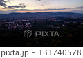 Experience a stunningly beautiful aerial view of a magnificent cityscape surrounded by lush hills during sunset 131740578