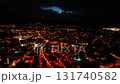 A breathtaking aerial view of a colorful city illuminated at night, featuring vibrant lights under a dramatic sky 131740582