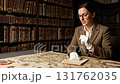 Female historian in tweed jacket and gloves working with an old vintage map in a library 131762035