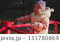 Child enjoys a fun ride on a colorful carousel in a sunny park during autumn 131780869