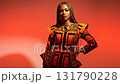 Confident black woman in modern orange african print designer dress posing in fashion studio 131790228