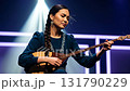 Young central asian artist playing a traditional kazakh dombyra with feeling under a spotlight 131790229