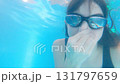 Funny teen girl in swimming goggles looking at camera in pool 131797659