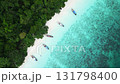 Aerial view of Monkey Beach on Ko Phi Phi Island, Thailand, showing turquoise sea, white sandy beach, tropical jungle and traditional long tail boats anchored near the shore. 131798400
